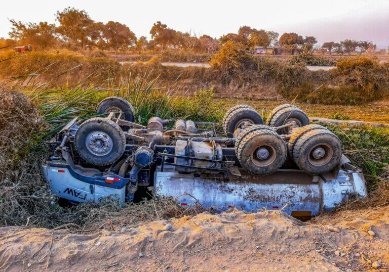 wrecked truck upside down on roadside